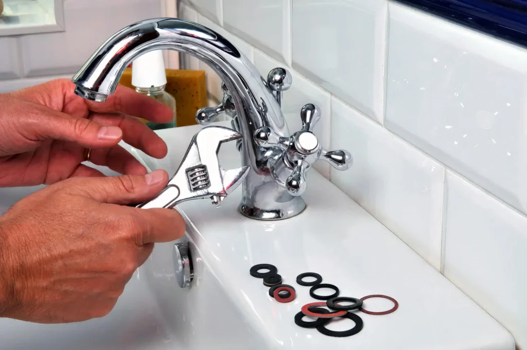 Plumber performing maintenance on a bathroom faucet in Brentwood