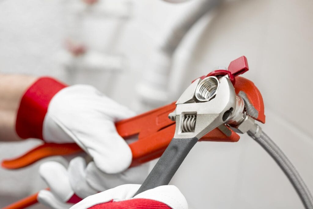 Plumber holding pipe wrenches for an emergency repair in Brentwood