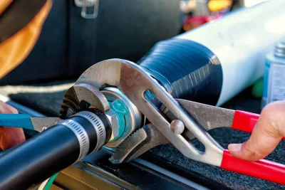 Technician tightening an industrial pipe connection in Brentwood