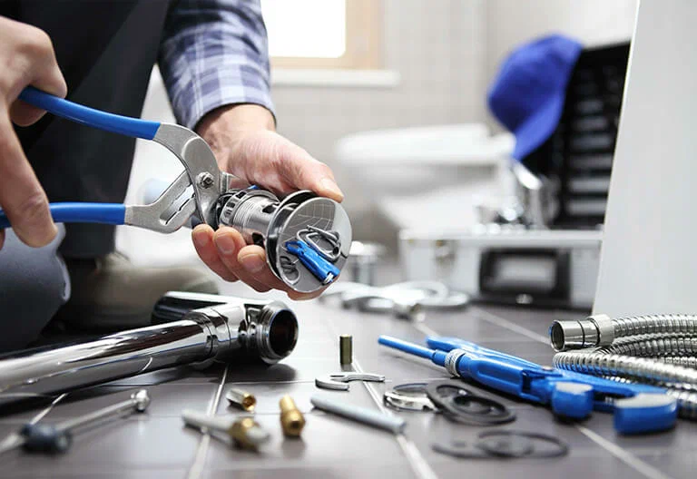 Technician repairing a plumbing fixture with professional tools in Brentwood