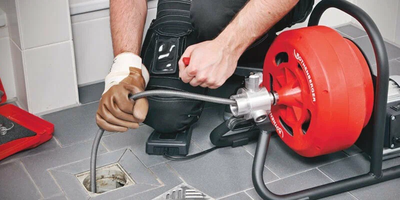 Plumber using a drain-cleaning machine in Brentwood