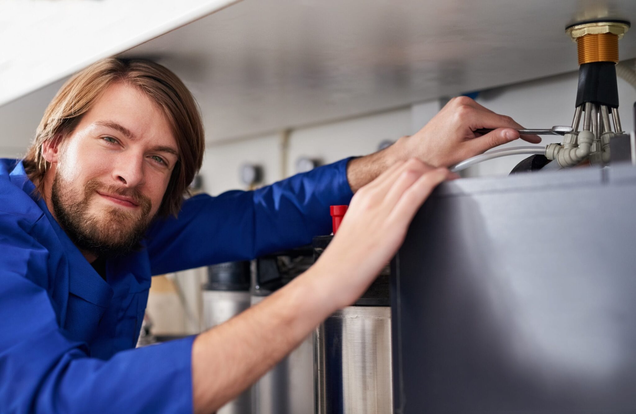Technician servicing a residential water heater tank in Brentwood